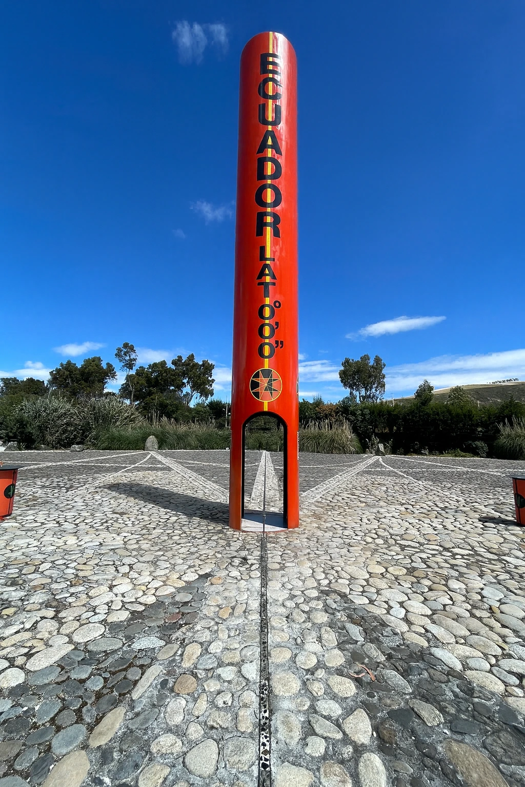 The Ecuador equator monument marking latitude 0°0′0″, photographed on a clear blue-sky day.